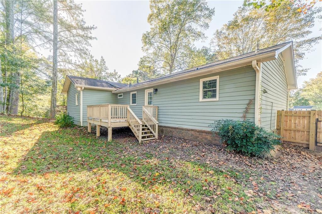 3016 Butler Creek Road Northwest Kennesaw, GA 30152 - Photo 9 of 43 a white house that has a small yard and large trees