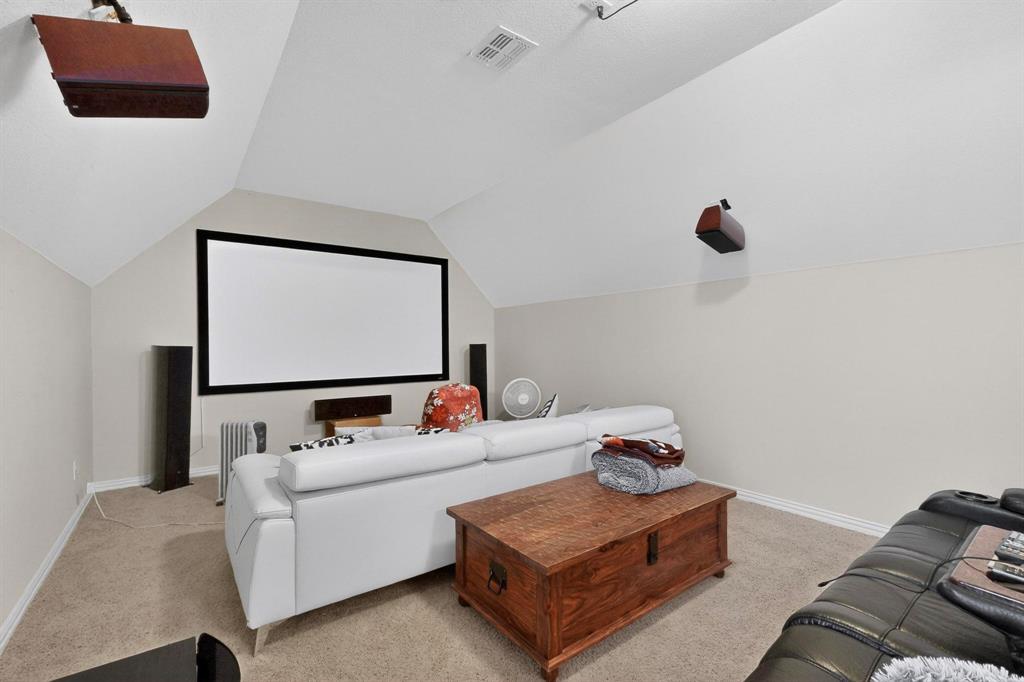 7625 Ridgedale Court Sachse, TX 75048 - Photo 32 of 40 Home theater room with light colored carpet and lofted ceiling