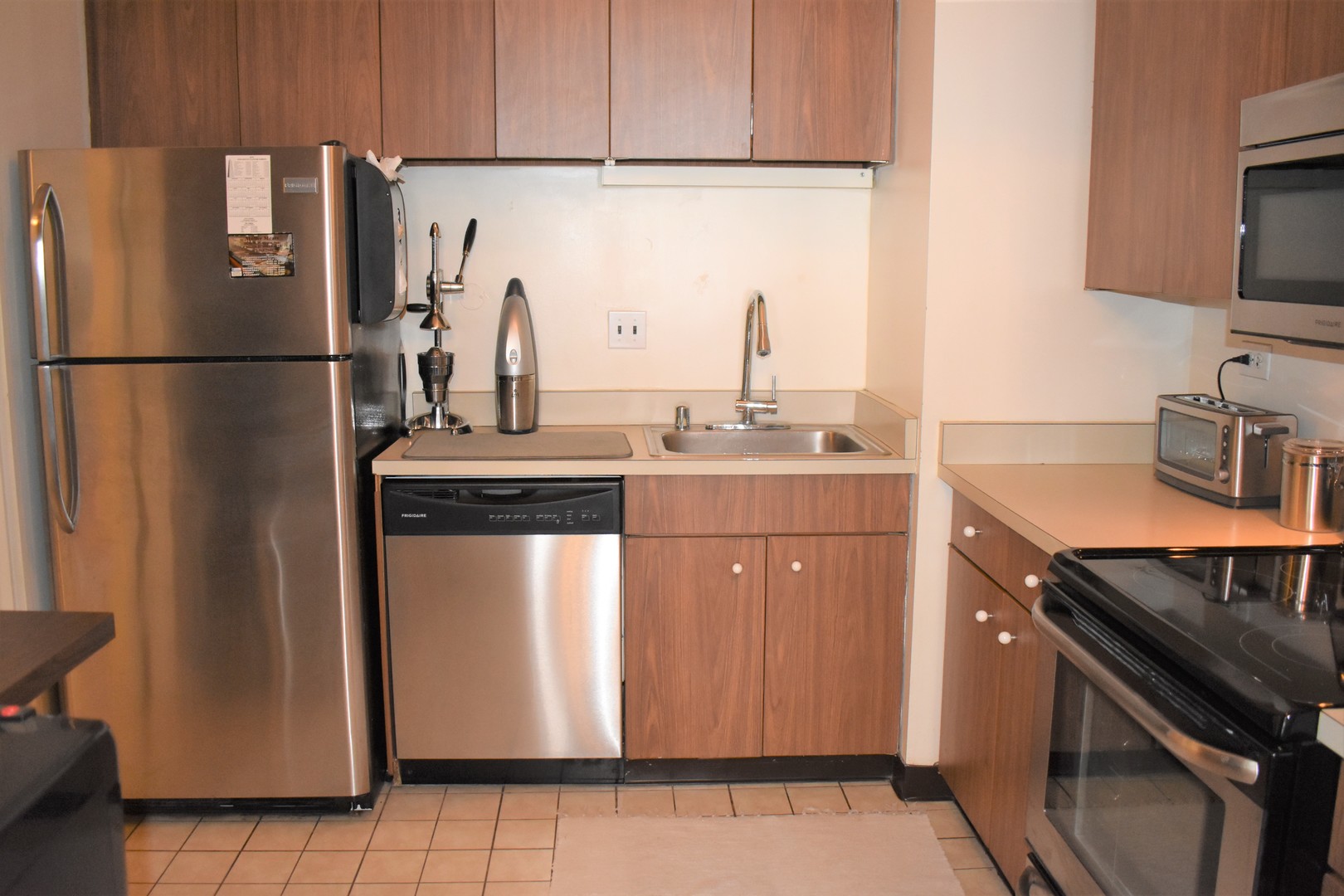 175 East Delaware Place, Unit 5501 Chicago, IL 60611 - Photo 16 of 37 a kitchen with stainless steel appliances granite countertop a refrigerator a sink and a stove