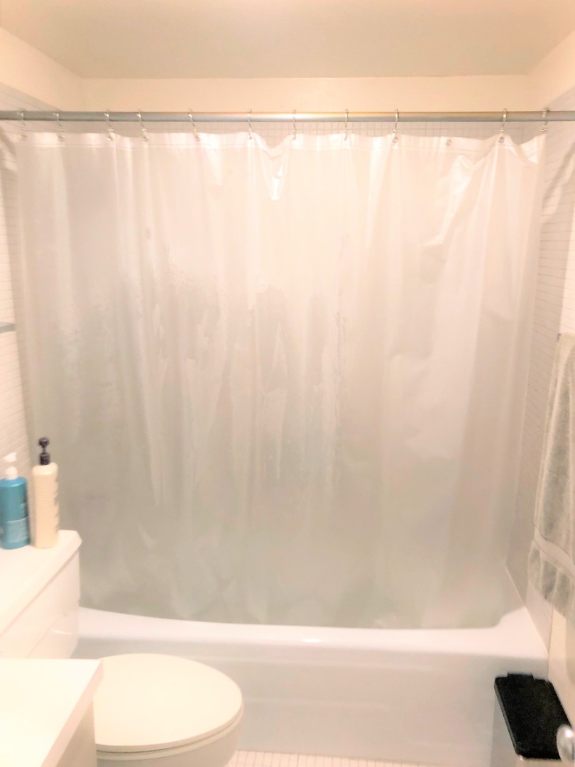 175 East Delaware Place, Unit 5501 Chicago, IL 60611 - Photo 23 of 37 a bathroom with a shower curtain and a bathtub