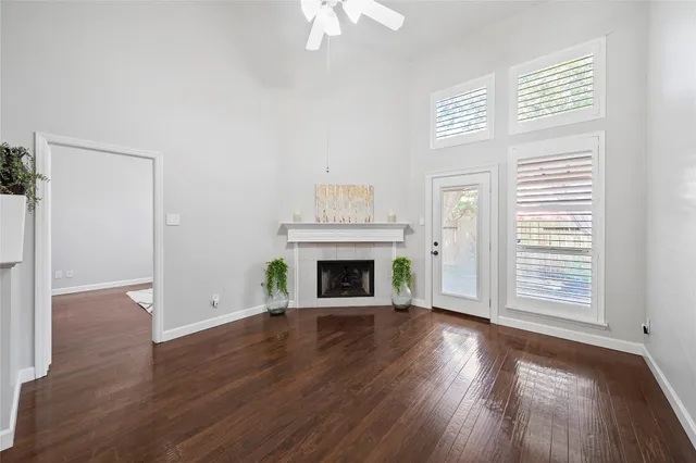 a view of a livingroom with wooden floor a fireplace and window