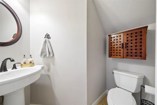 a bathroom with a toilet a sink and a mirror