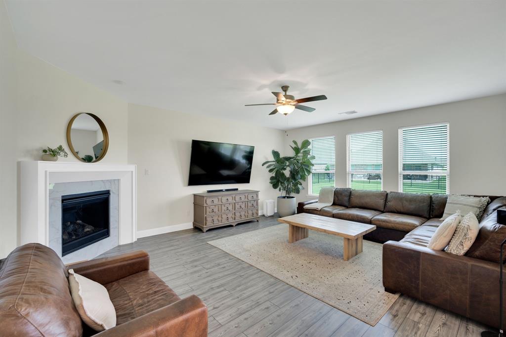 1601 Bear Path Way Gunter, TX 75058 - Photo 5 of 40 a living room with furniture a flat screen tv and a fireplace