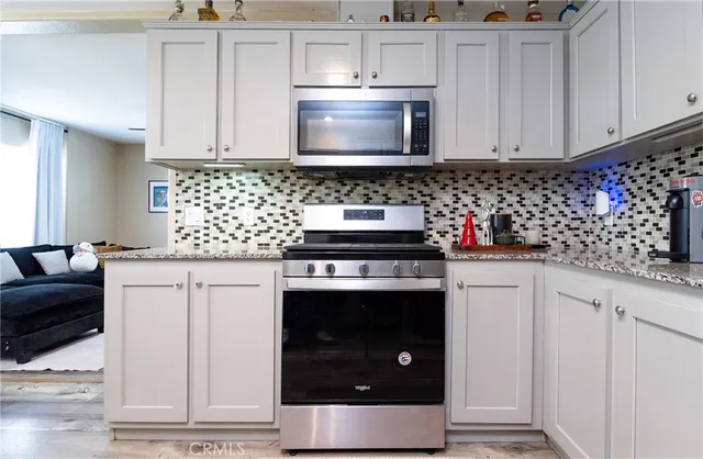 a kitchen with stainless steel appliances granite countertop a stove a microwave and cabinets