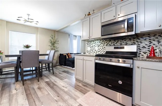 a kitchen with stainless steel appliances kitchen island granite countertop a stove a sink and a microwave