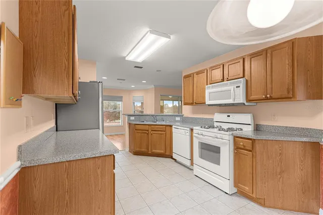 a kitchen with stainless steel appliances granite countertop a stove a sink dishwasher and a refrigerator