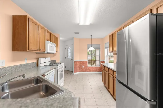 a kitchen with stainless steel appliances granite countertop a refrigerator and a sink