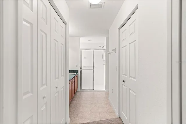 a view of a hallway with white cabinets