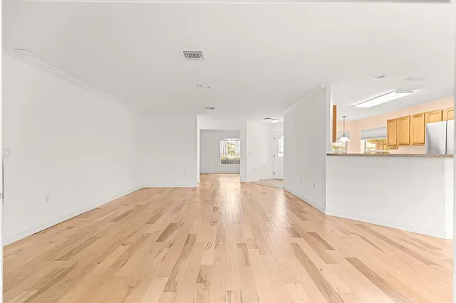 a view of a big room with wooden floor and a window