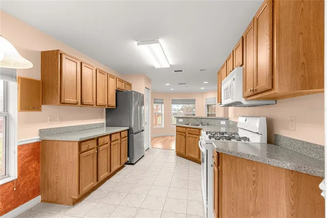 a kitchen with stainless steel appliances granite countertop a stove a sink dishwasher and a refrigerator