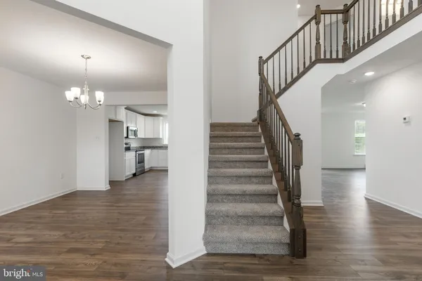 a view of a hallway with wooden floor and staircase