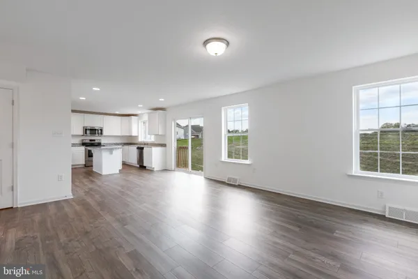 a view of a kitchen with a sink wooden cabinets and a window