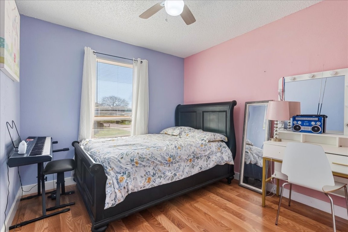 12926 Grovemill Drive Houston, TX 77045 - Photo 18 of 30 a bedroom with a bed and a chandelier