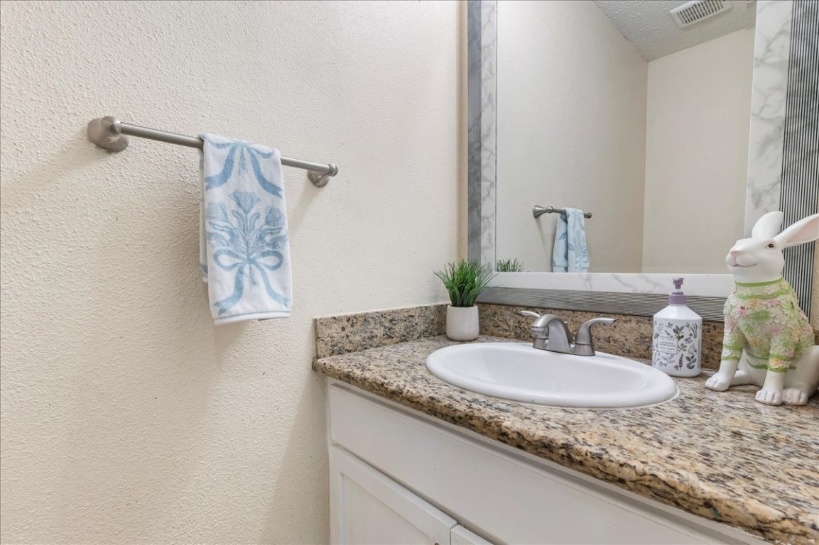 12926 Grovemill Drive Houston, TX 77045 - Photo 7 of 30 a bathroom with a granite countertop sink and a mirror