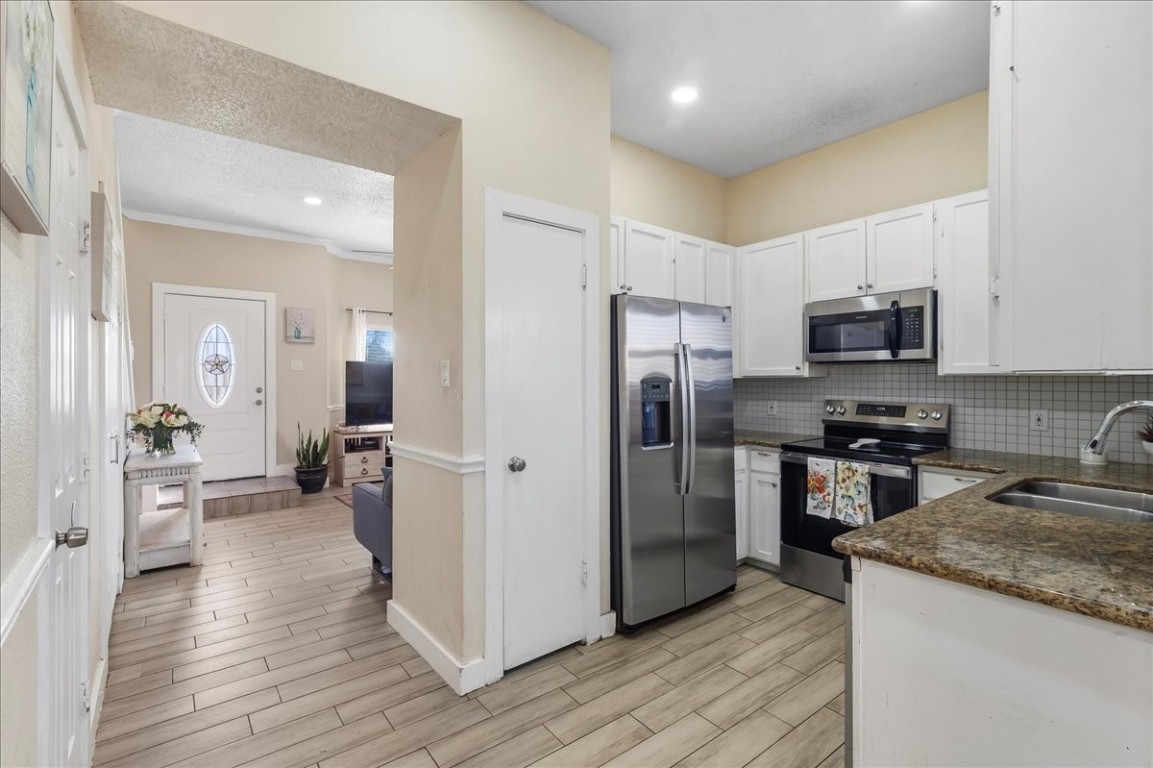 12926 Grovemill Drive Houston, TX 77045 - Photo 10 of 30 a kitchen with a refrigerator microwave and stove