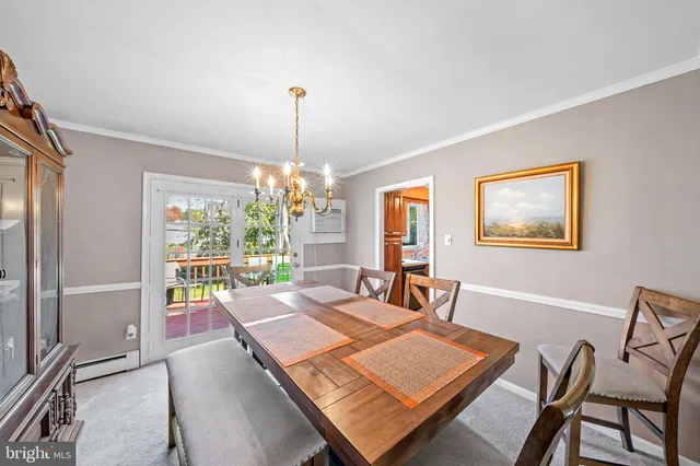 a view of a dining room with furniture a chandelier and wooden floor
