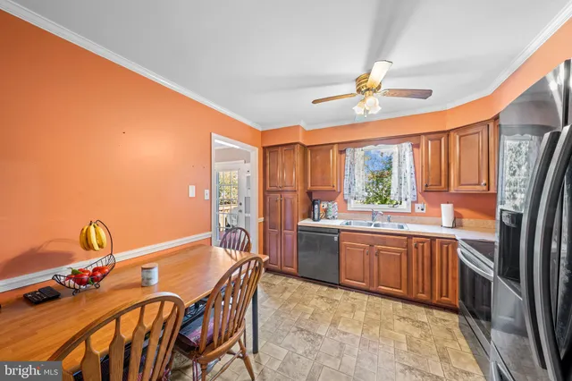 a kitchen with stainless steel appliances granite countertop a stove top oven a sink dishwasher and dining table with chairs