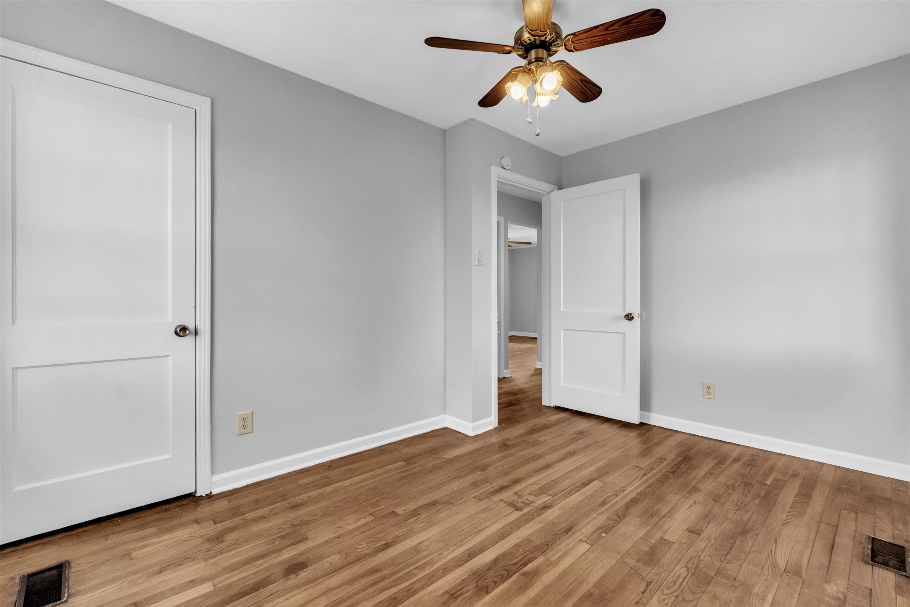 1887 North Graham Street Memphis, TN 38108 - Photo 6 of 13 an empty room with wooden floor a ceiling fan and closet