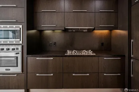 a kitchen with granite countertop a sink stainless steel appliances and cabinets