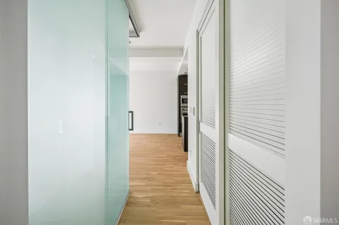 a view of a hallway with wooden floor and entryway