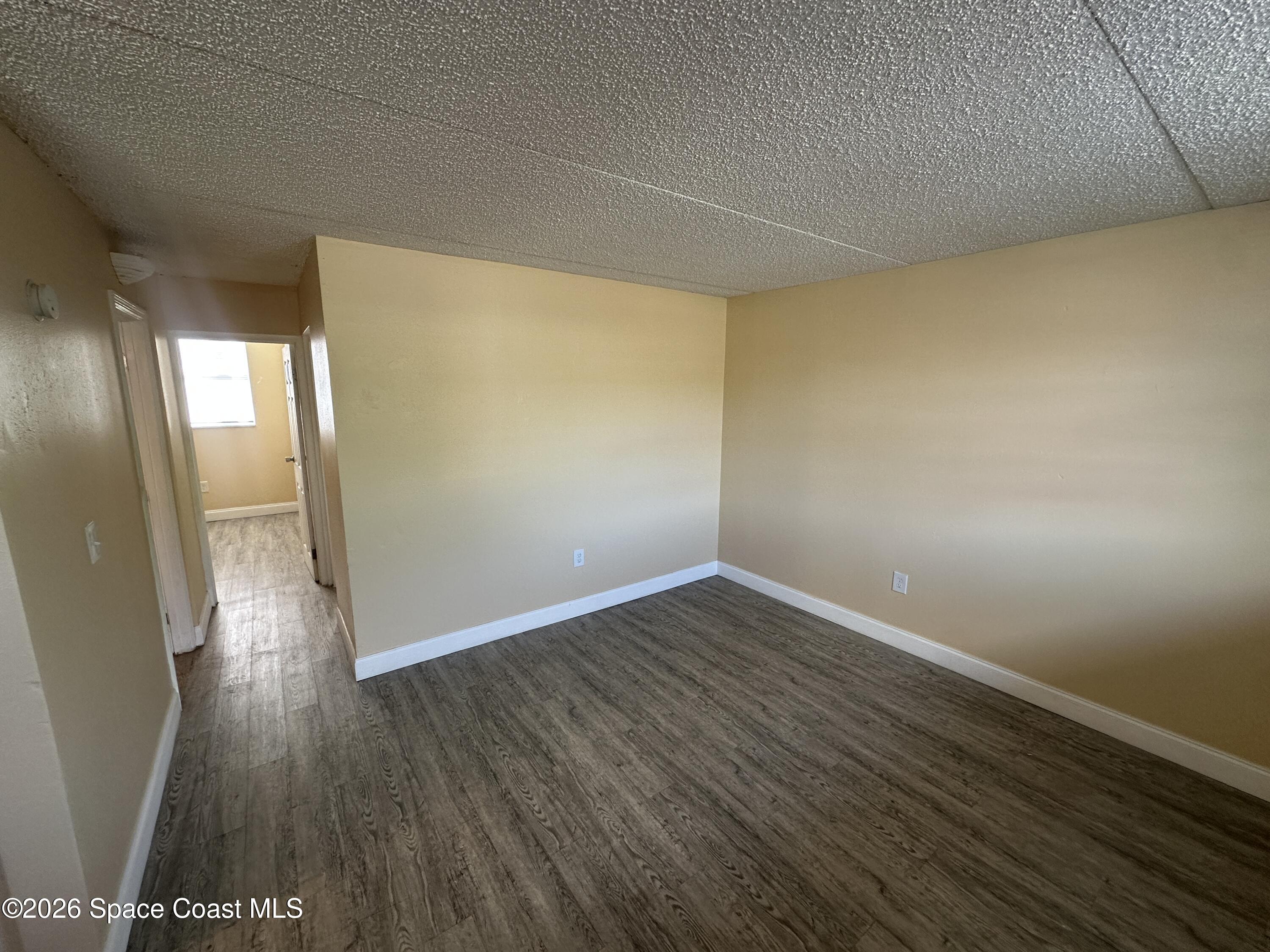 240 Stone Street, Unit 6 Cocoa, FL 32922 - Photo 2 of 7 an empty room with wooden floor and windows
