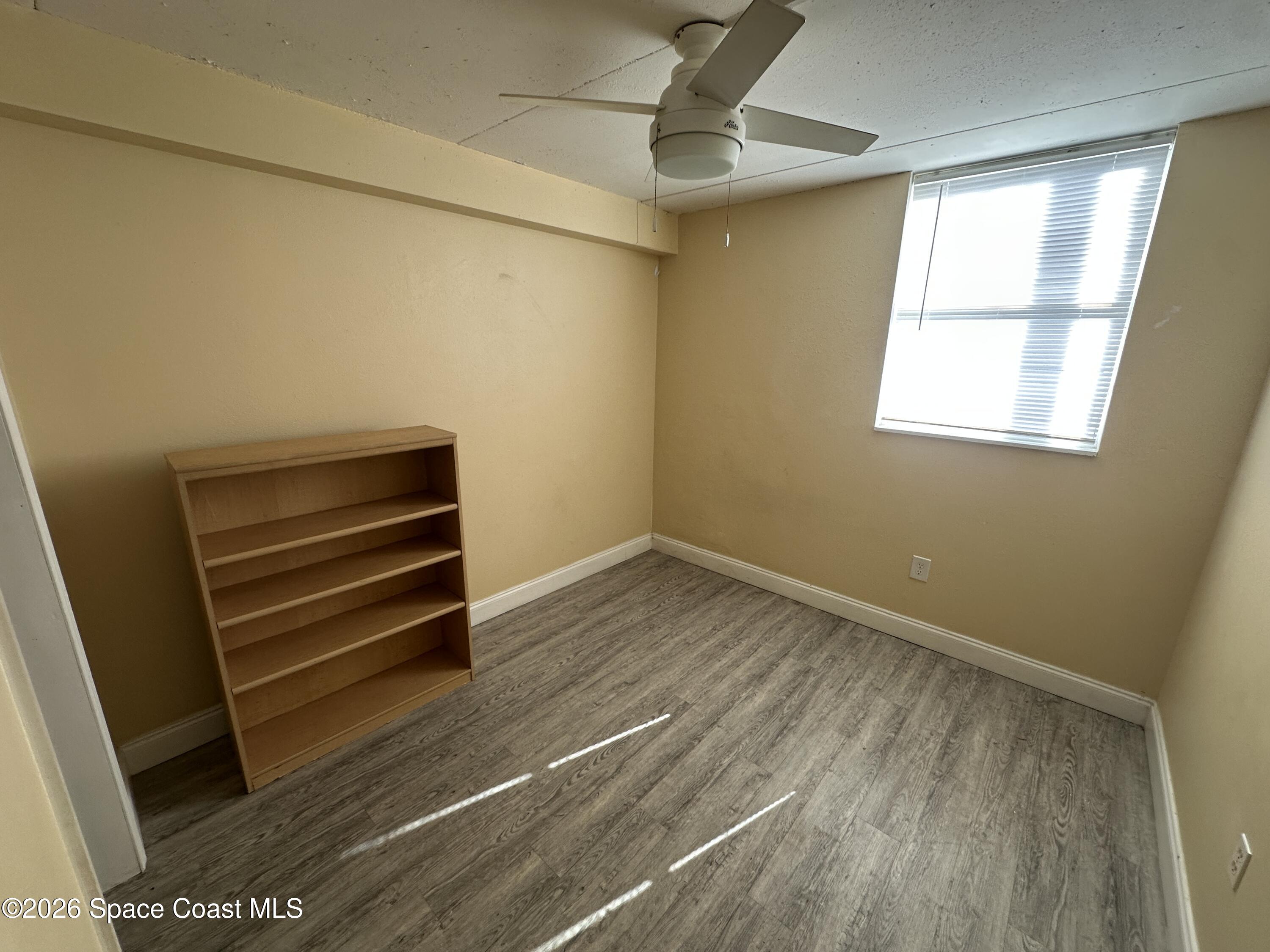 240 Stone Street, Unit 6 Cocoa, FL 32922 - Photo 5 of 7 a view of empty room with wooden floor and fan