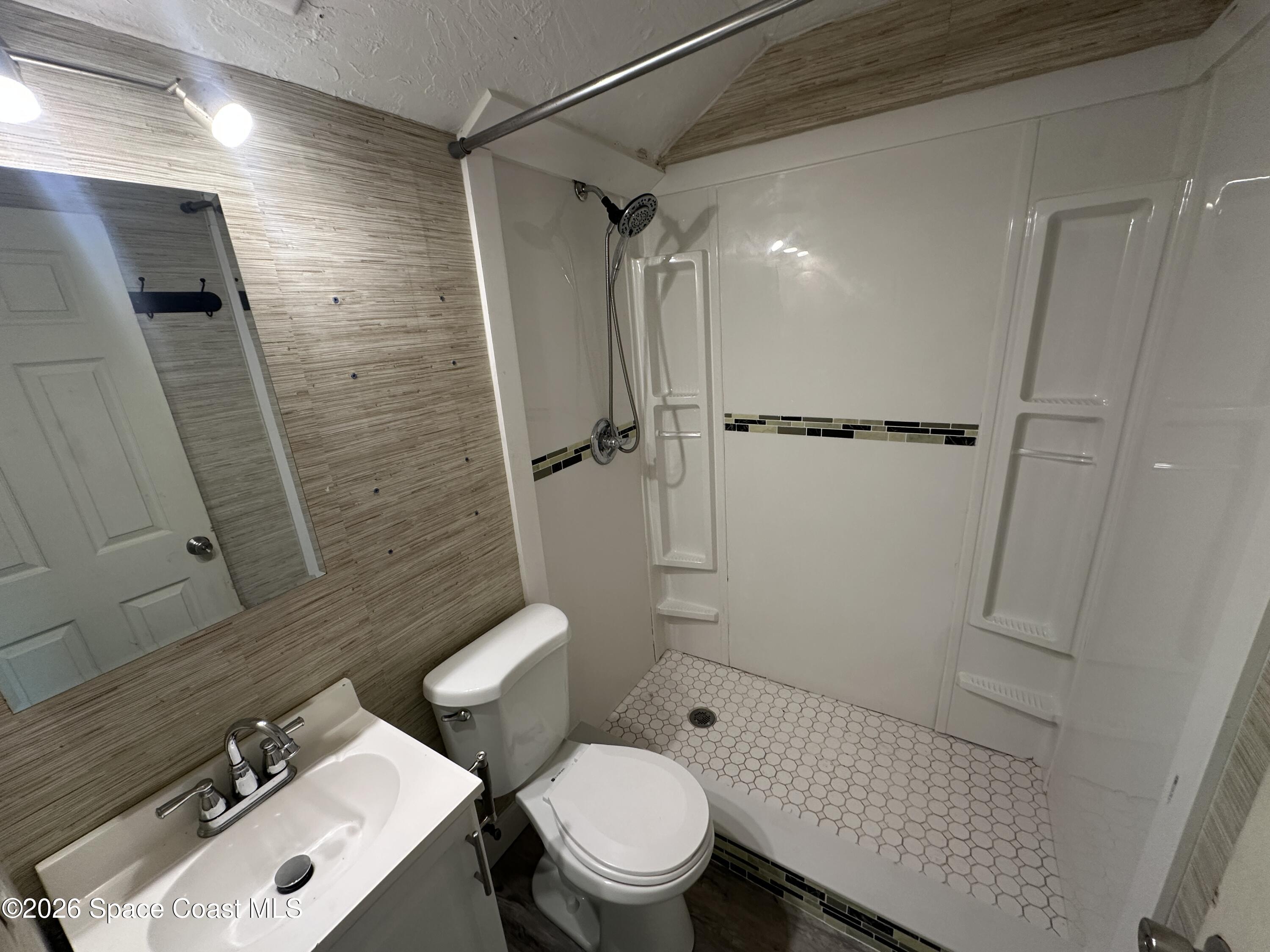 240 Stone Street, Unit 6 Cocoa, FL 32922 - Photo 7 of 7 a bathroom with a sink a toilet and shower