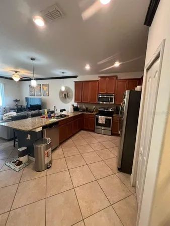 a kitchen with kitchen island granite countertop stainless steel appliances a counter top space cabinets and a sink