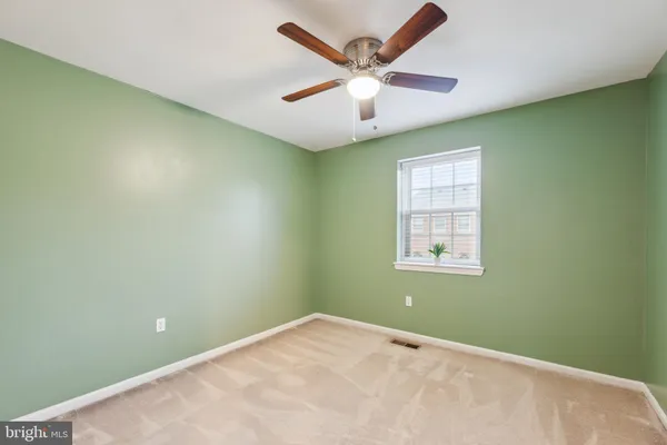an empty room with a window and a ceiling fan