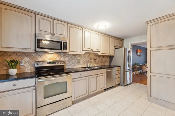 a kitchen with granite countertop a refrigerator stove and microwave