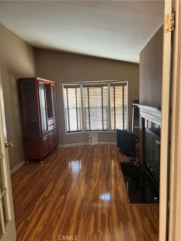 a view of a livingroom with wooden floor and a window