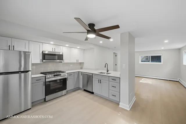 a kitchen with white cabinets and stainless steel appliances