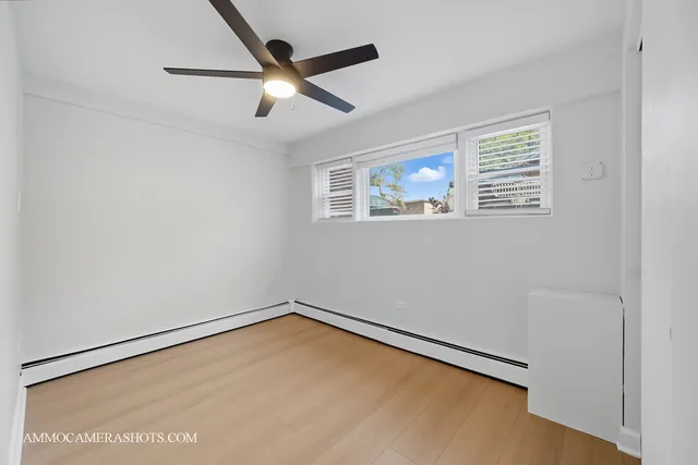 a view of a big room with wooden floor and windows