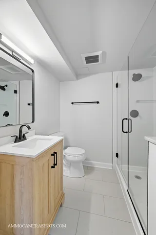 a spacious bathroom with a granite countertop sink a toilet and a mirror