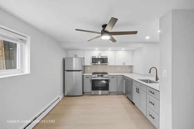 a large kitchen with stainless steel appliances granite countertop a stove and a sink