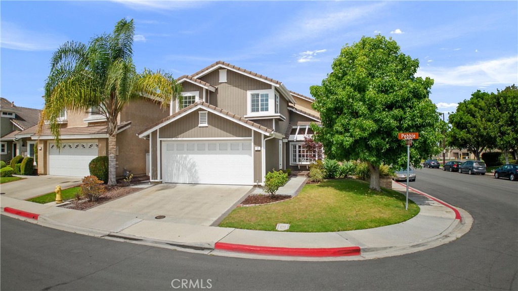 a view of a house with a yard and potted plants