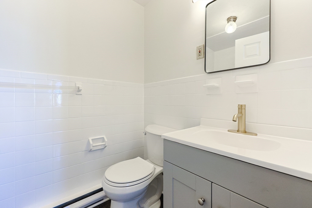 224 School Street, Unit 9 Walpole, MA 02081 - Photo 18 of 31 a bathroom with a sink mirror and toilet