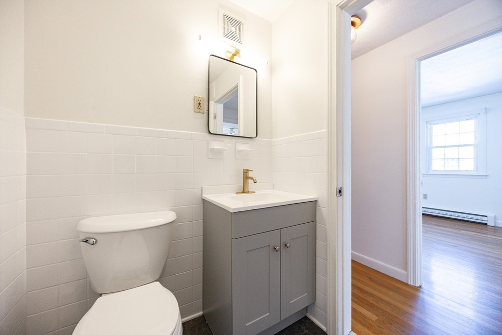 224 School Street, Unit 9 Walpole, MA 02081 - Photo 19 of 31 a bathroom with a toilet a sink and mirror