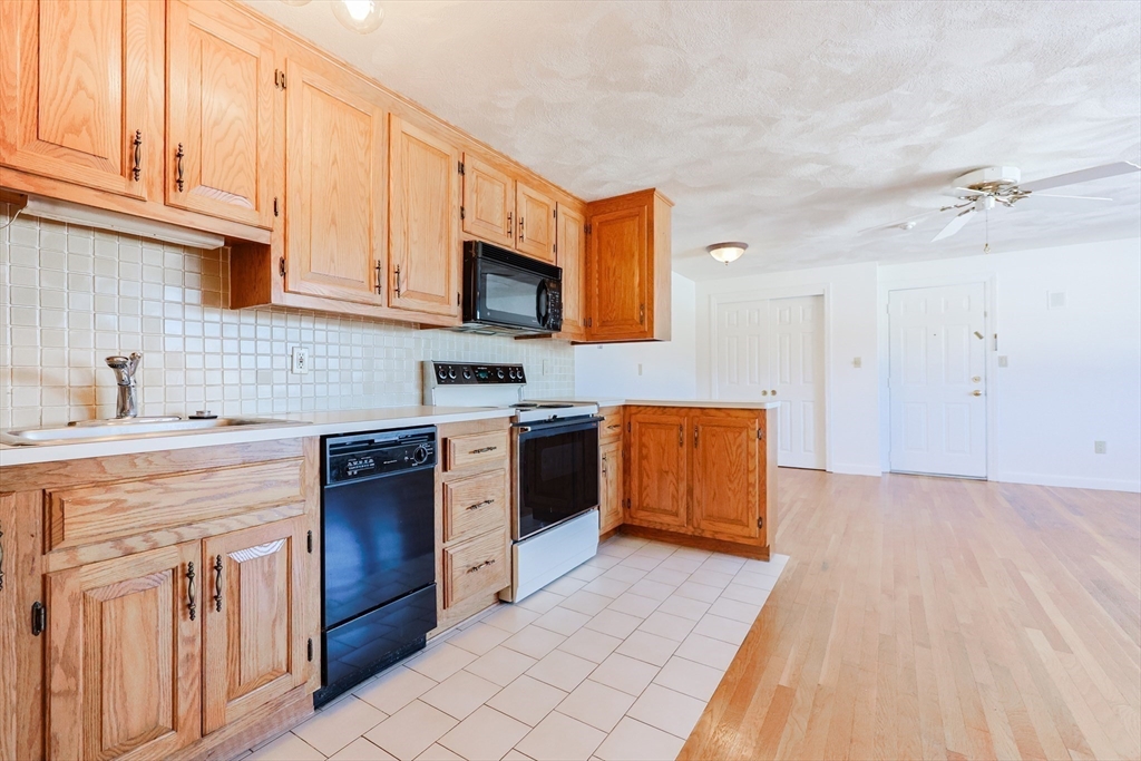 224 School Street, Unit 9 Walpole, MA 02081 - Photo 4 of 31 a kitchen with stainless steel appliances granite countertop a stove a sink and a microwave