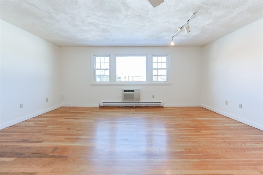 224 School Street, Unit 9 Walpole, MA 02081 - Photo 8 of 31 a view of empty room with wooden floor and fan