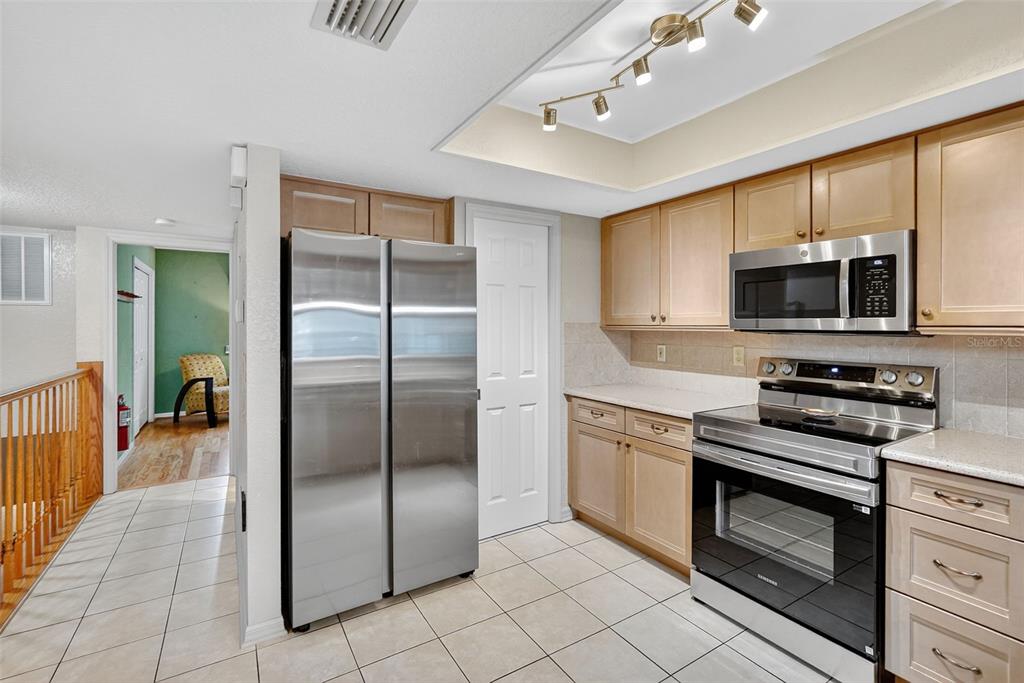 14879 Seminole Trail Seminole, FL 33776 - Photo 5 of 40 a kitchen with granite countertop a refrigerator a stove top oven a sink and dishwasher