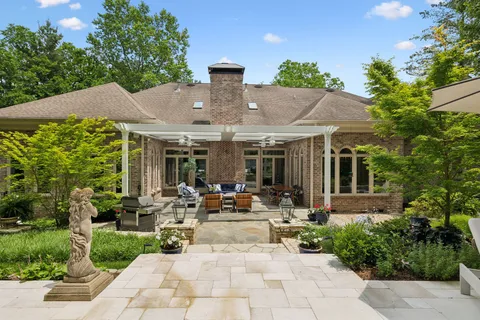 a view of a patio with table and chairs potted plants and floor to ceiling window
