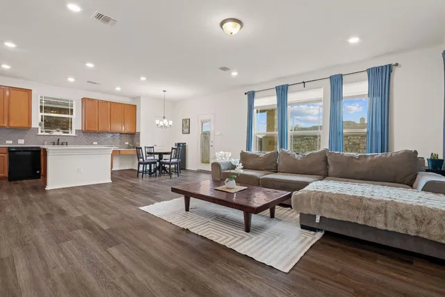 a living room with furniture and a wooden floor