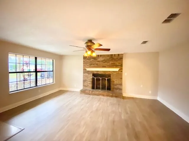 a view of an empty room with a fireplace and a window