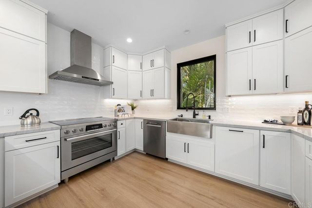 a kitchen with white cabinets appliances and a sink