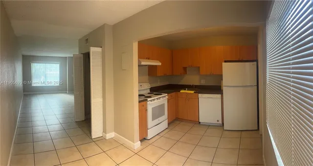 a kitchen with a stove a refrigerator and a sink