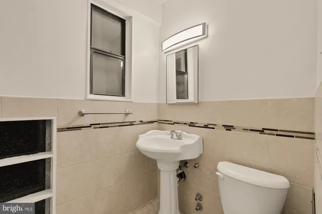 a bathroom with a sink toilet and mirror