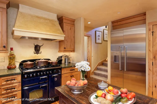 a kitchen with stainless steel appliances kitchen island granite countertop a stove and a refrigerator