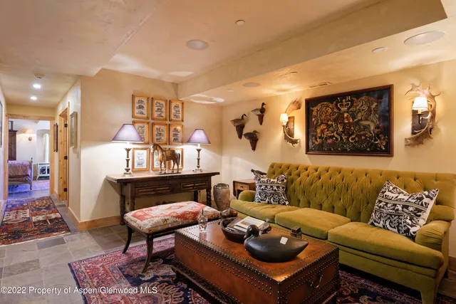 a living room with furniture a rug and a wall painting