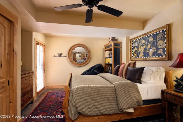 a bedroom with a bed and painting on the wall